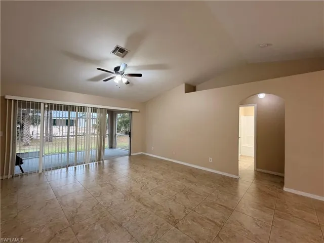Spare room with arched walkways, a ceiling fan, and vaulted ceiling