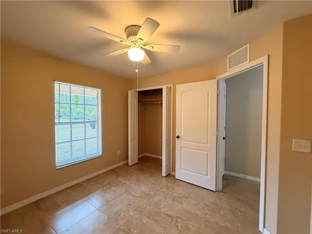 Unfurnished bedroom with a ceiling fan and a closet