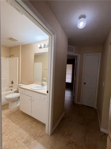 Bathroom featuring vanity,  shower combination, and light tile patterned flooring