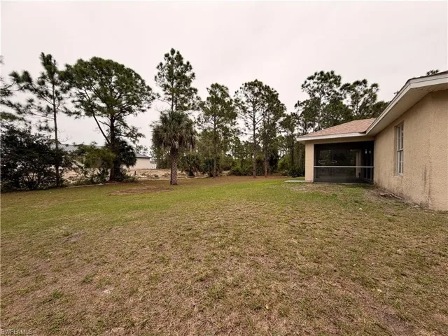 View of green lawn with a sunroom