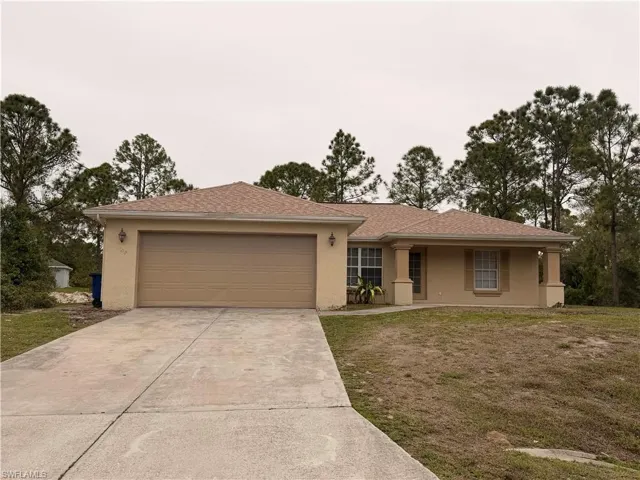 Ranch-style home with stucco siding, a garage, driveway, and roof with shingles