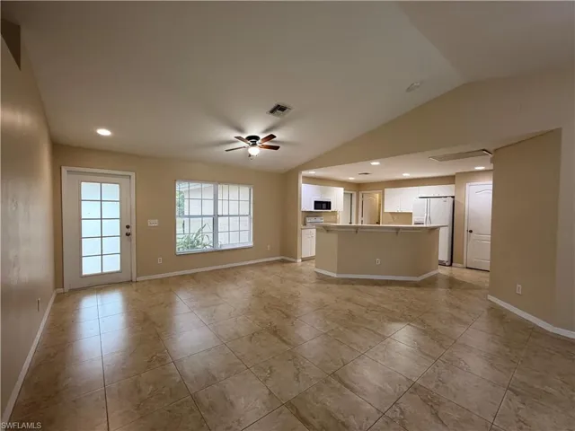 Unfurnished living room featuring ceiling fan, recessed lighting, and lofted ceiling
