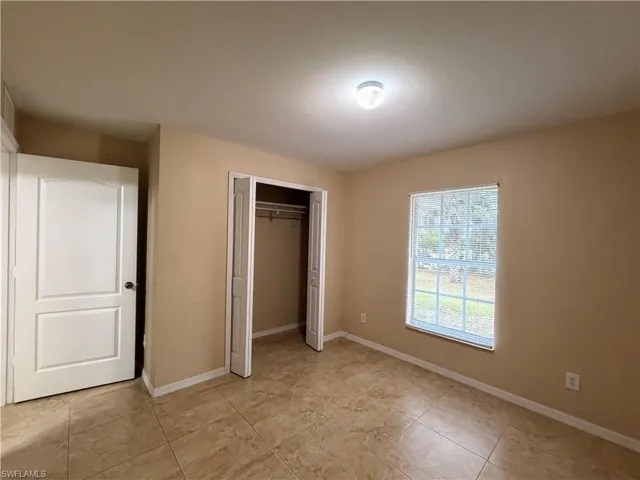 Unfurnished bedroom featuring baseboards and a closet