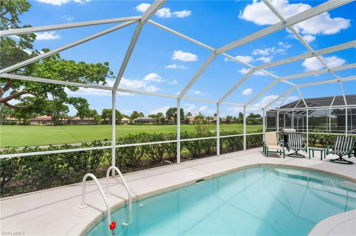View of swimming pool with a lanai, a patio area, and a lawn