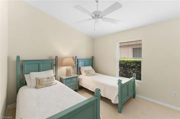 Carpeted bedroom featuring ceiling fan