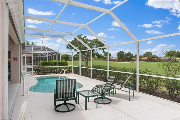 View of swimming pool featuring glass enclosure and a patio area