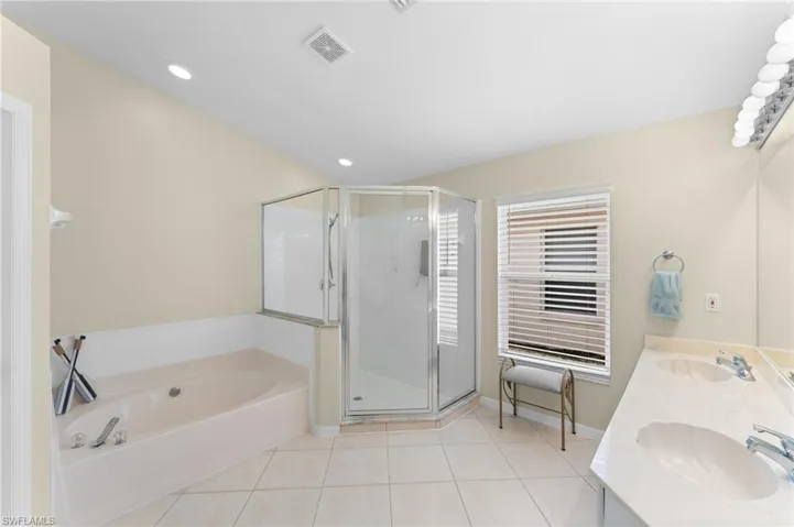 Master bathroom with tile patterned flooring, vanity, and shower with separate bathtub