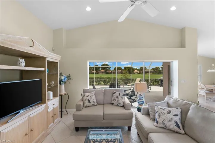 Living room with beam ceiling, ceiling fan, high vaulted ceiling, and light tile patterned floors