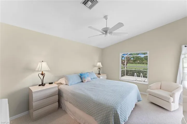 Carpeted master bedroom with ceiling fan and lofted ceiling