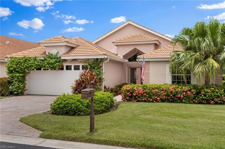 Mediterranean / spanish home featuring a garage and a front yard