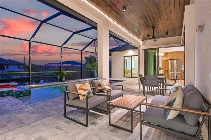 Screened lanai featuring a swimming pool, integrated spa, and water frontage