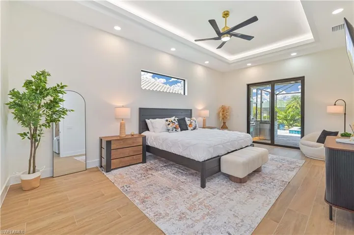 Recessed lighting illuminates a tray ceiling with a modern ceiling fan
