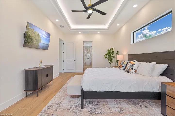 Recessed lighting and a ceiling fan adorn the tray ceiling