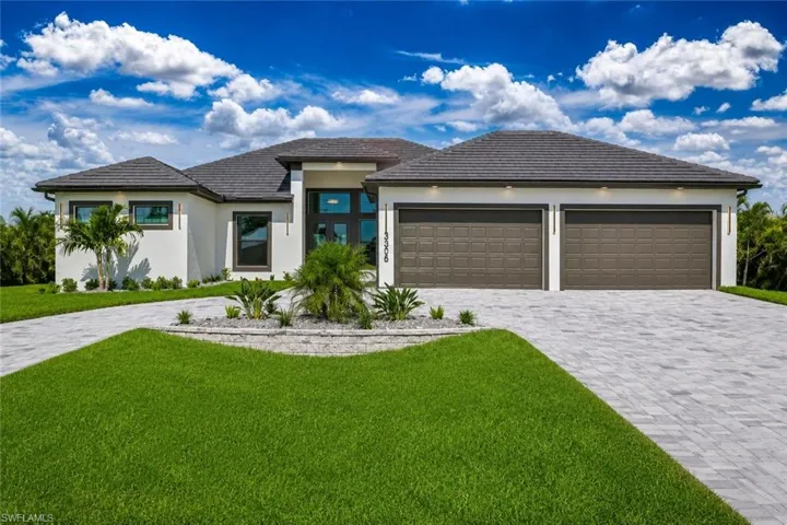 Contemporary stucco exterior with a dark tile roof, a paver driveway, and a two-car garage