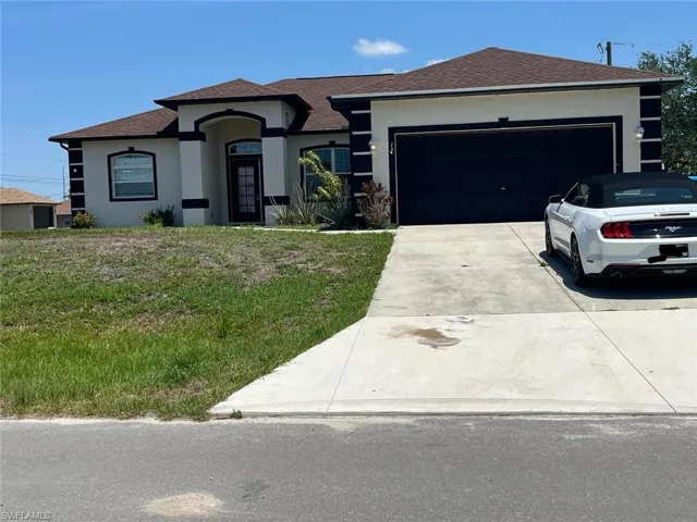 View of front of property featuring stucco siding, driveway, an attached garage, a shingled roof, and a front yard
