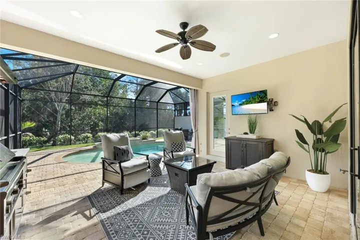 Covered patio featuring outdoor kitchen with Lynx Grill/Hood, stainless storage drawers and cabinets, beverage cooler, stainless sink, recessed lighting, ceiling fan, fire pit and lounge area