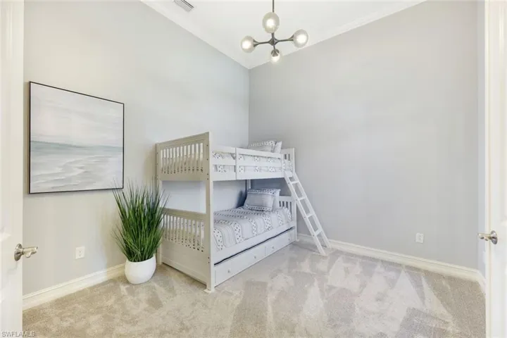 Bedroom/Den with new carpet, an inviting chandelier, and crown molding