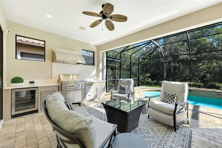 Covered patio featuring outdoor kitchen with Lynx Grill/Hood, stainless storage drawers and cabinets, beverage cooler, stainless sink, recessed lighting, ceiling fan, fire pit and lounge area