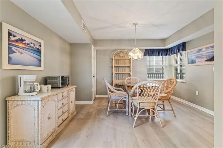 Dining space with light wood-style floors and suspended lighting
