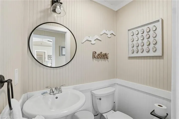 Half bath featuring crown molding and toilet - Virtually Edited Image