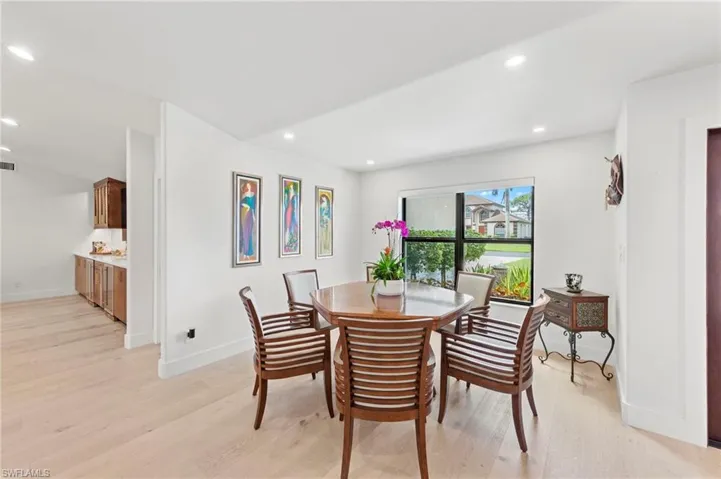 Dining area with light wood-style floors and recessed lighting