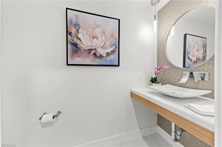Half bath with baseboards and backsplash