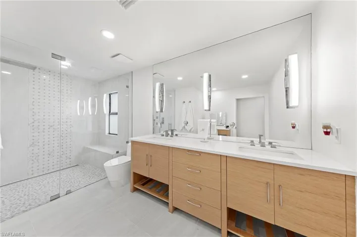 Bathroom with a shower stall, double vanity, light tile patterned flooring, and recessed lighting