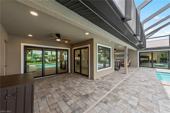 View of patio with ceiling fan, a lanai, and an outdoor pool
