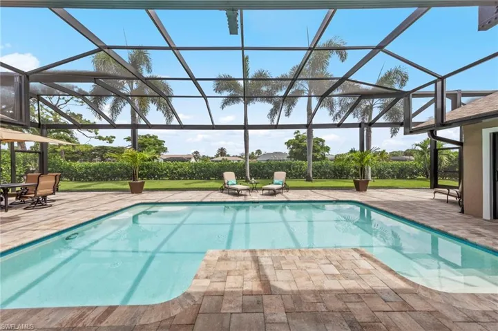 Outdoor pool featuring a sunroom, a patio, and a lanai
