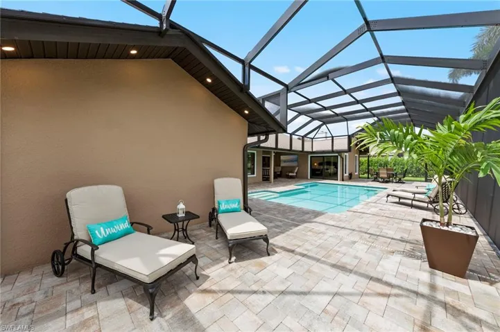 Swimming pool with a patio area, a sunroom, and a lanai