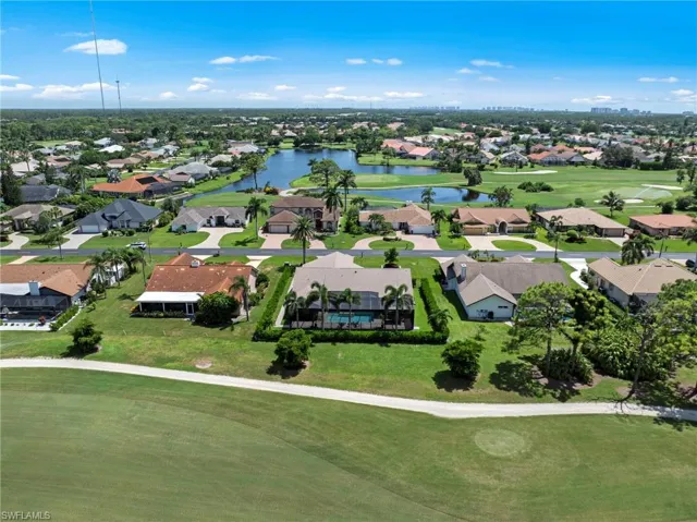 Aerial perspective of suburban area featuring a large body of water and a local golf course