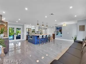 Living with french doors, ornamental molding, baseboards, and recessed lighting