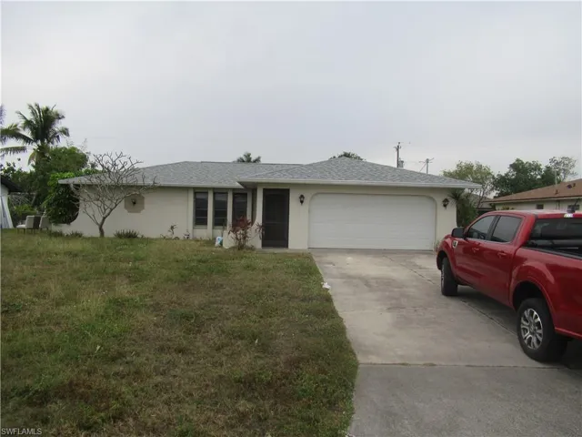Ranch-style house with a garage, a front yard, and central air condition unit