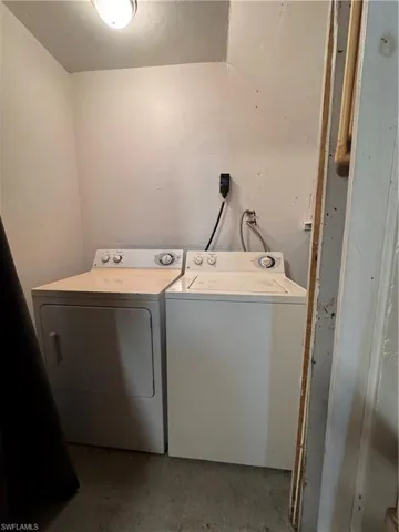 Washroom with washer and clothes dryer and concrete floors