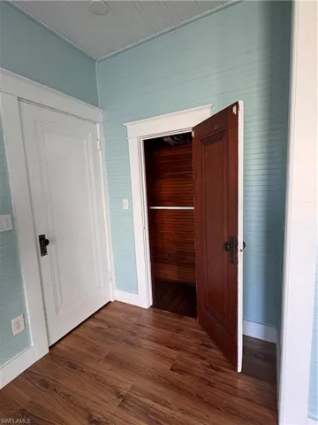 Corridor featuring dark wood finished floors and wood walls