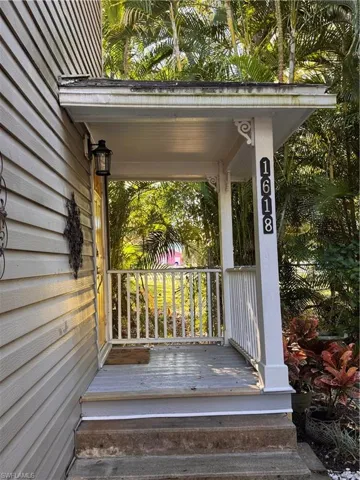Doorway to property featuring a porch and a security system
