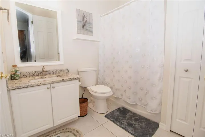Second bathroom features a granite vanity and tub with shower.