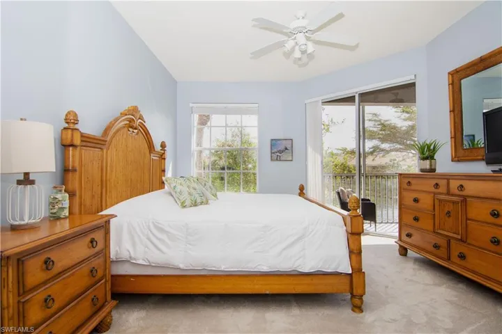 Primary Bedroom suite features plush wall to wall carpeting and a sliding door with direct entry to the screened lanai.