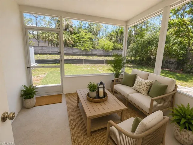 Screened porch featuring a slatted wood-finish coffee table and a neutral rug