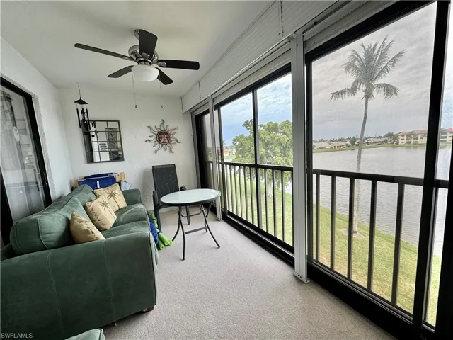 Sunroom / solarium with a water view and ceiling fan