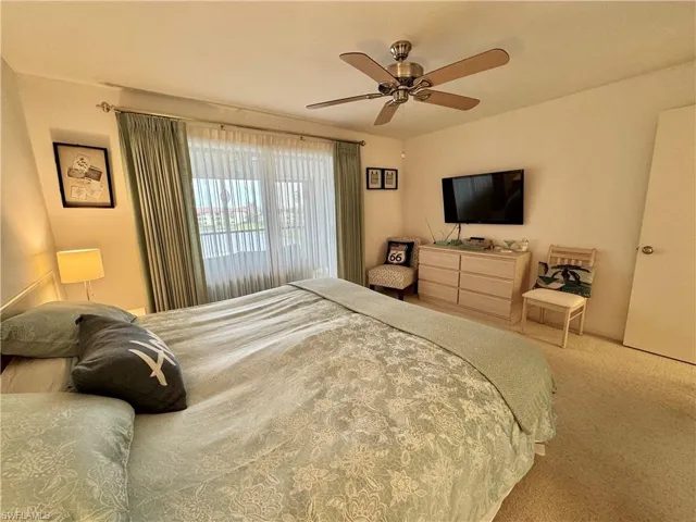 Carpeted bedroom featuring ceiling fan