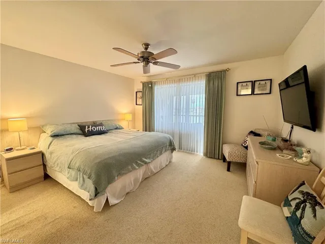 Carpeted bedroom featuring ceiling fan