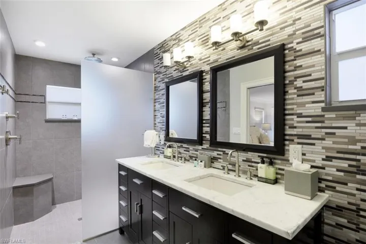 Full bath featuring tasteful backsplash, walk in shower, double vanity, and recessed lighting