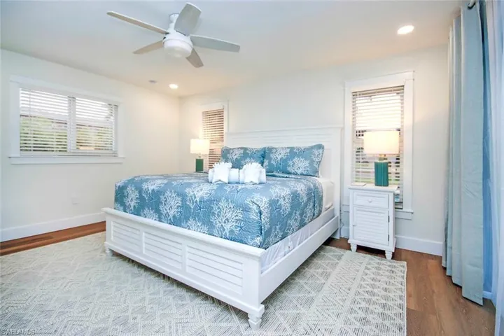 Bedroom featuring a ceiling fan, multiple windows, wood finished floors, and recessed lighting