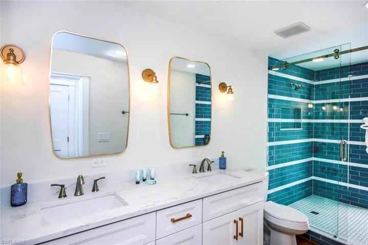 Bathroom featuring double vanity and a stall shower