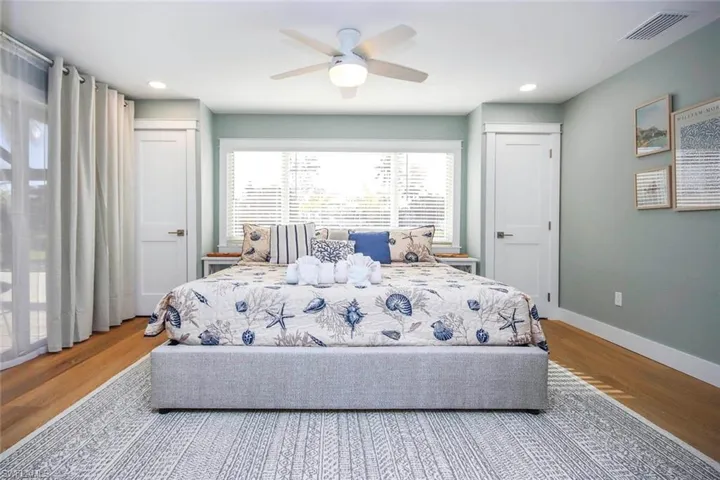 Bedroom with wood finished floors, access to exterior, a ceiling fan, and recessed lighting