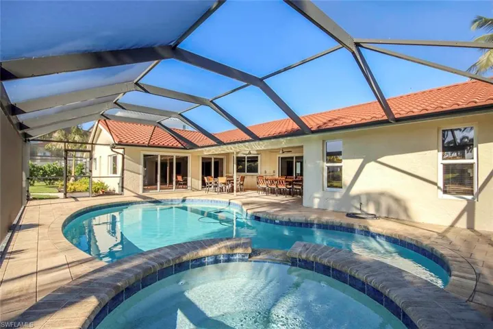View of swimming pool with a sunroom, a patio, a pool with connected hot tub, and glass enclosure