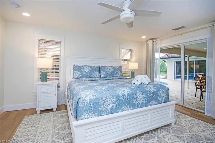 Bedroom featuring wood finished floors, access to outside, a ceiling fan, and recessed lighting