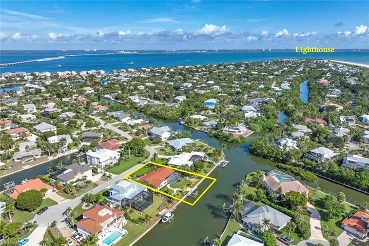 Aerial perspective of suburban area featuring a large body of water and property parcel outlined