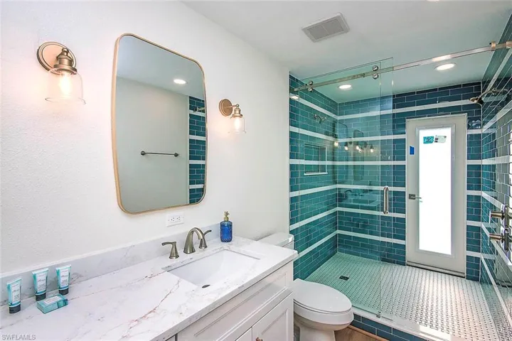 Bathroom with vanity, a stall shower, and recessed lighting
